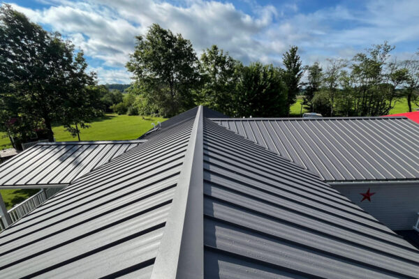 Complete residential gray standing seam metal roof installation with clean ridge lines in Cassadaga, NY, crafted by MW Home Improvements.
