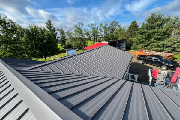Amish-crafted gray standing seam metal roof installation featuring crisp valley lines and multi-slope transitions in Cassadaga, NY, by MW Home Improvements.