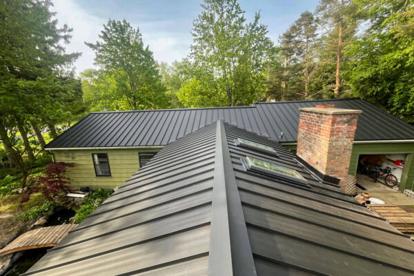 Modern matte black standing seam metal roof installation on a residential home.