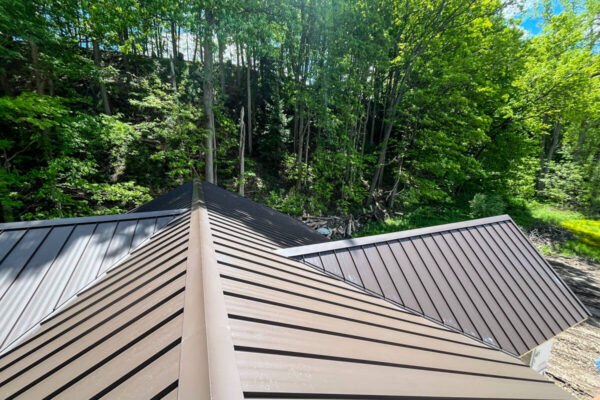Close-up perspective of intersecting hip lines and valleys on a premium metal roof installation.